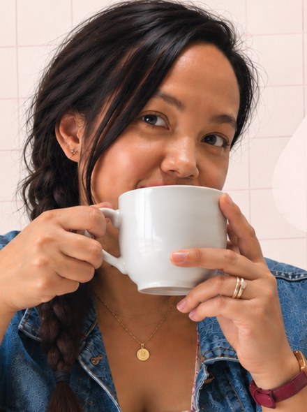 Mia, une tasse de café à la main